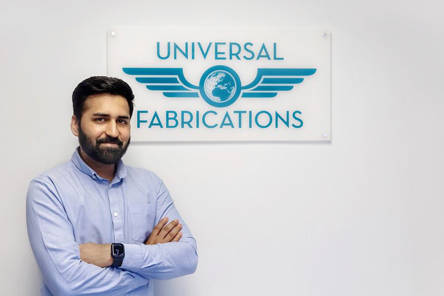 man standing in front. of Universal Fabrications logo representing the engineering skilled worker sponsorship program