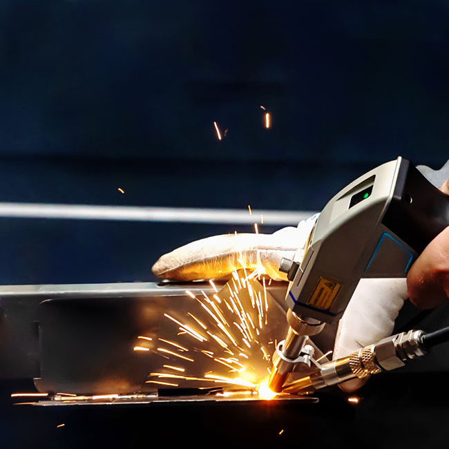 laser welding machine with sparks flying in use by a welder at metal fabricating company specialising in complex fabrications.