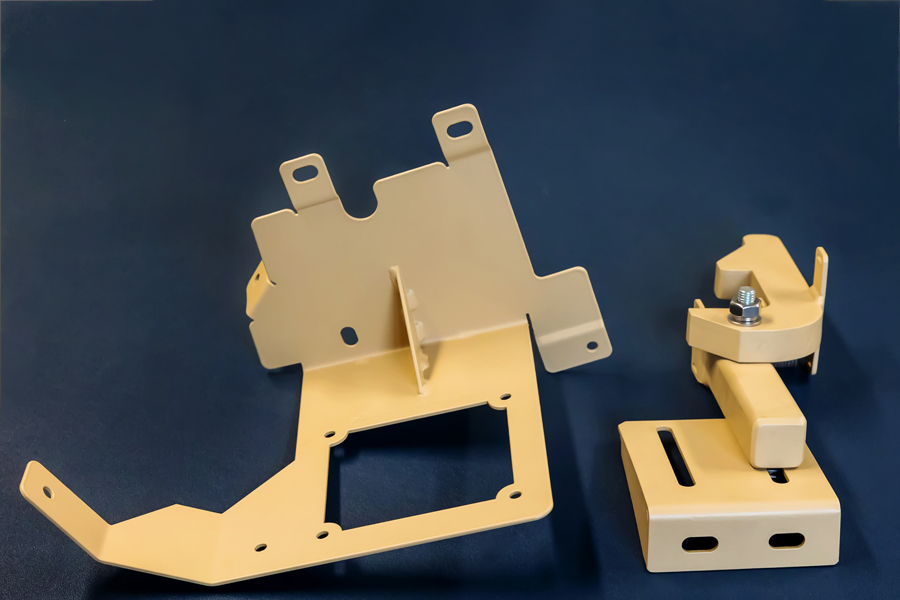 two production welded parts in desert tan manufactured by metal fabrication company in Coventry