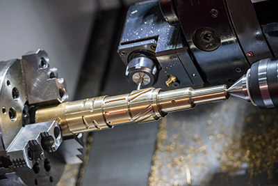 CNC lathe machine cutting the slot groove at the brass shaft Universal Fabrications brass machining specialists UK