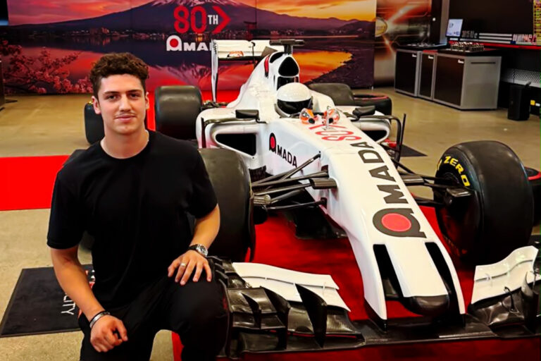 Universal Fabrications employee in front of racing car at Amada 80th celebrations