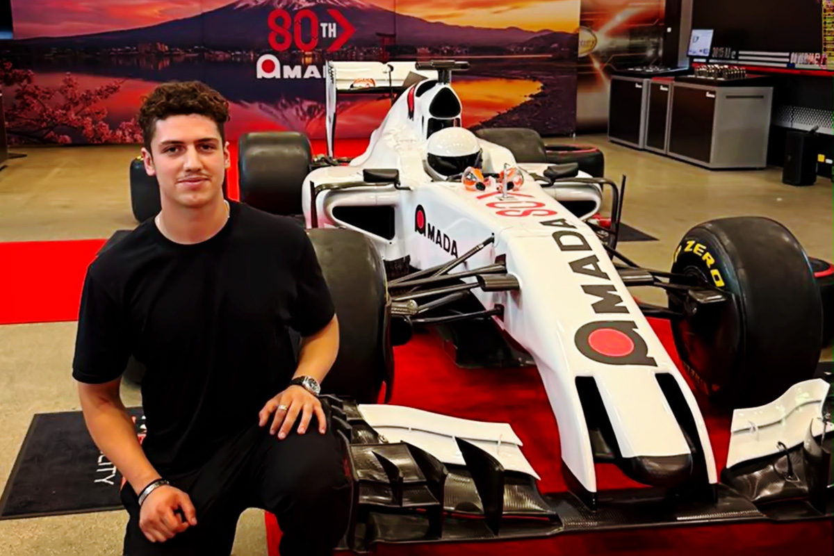 Universal Fabrications employee in front of racing car at Amada 80th celebrations
